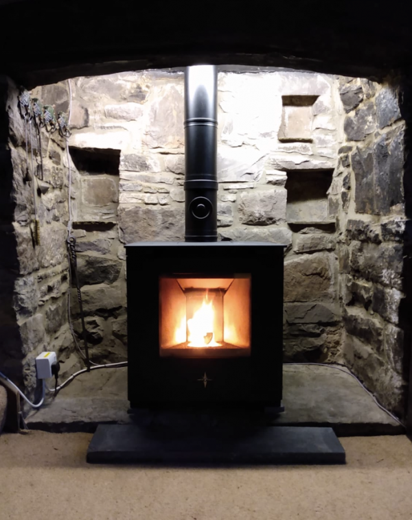 How do you heat a water with a wood burning stove that has a back